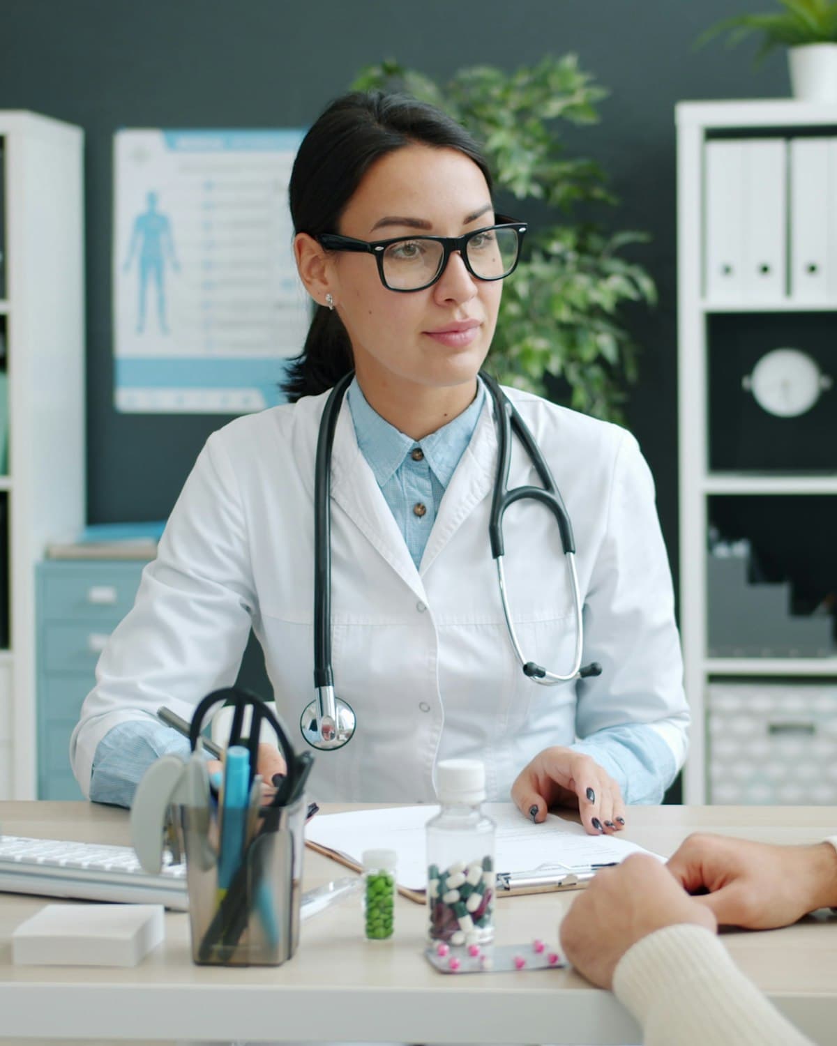 A doctor talking with a patient across the consulting room desk